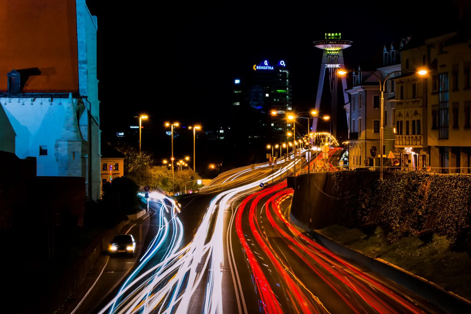 Estelas de luz de autos en una curva de la ciudad de noche